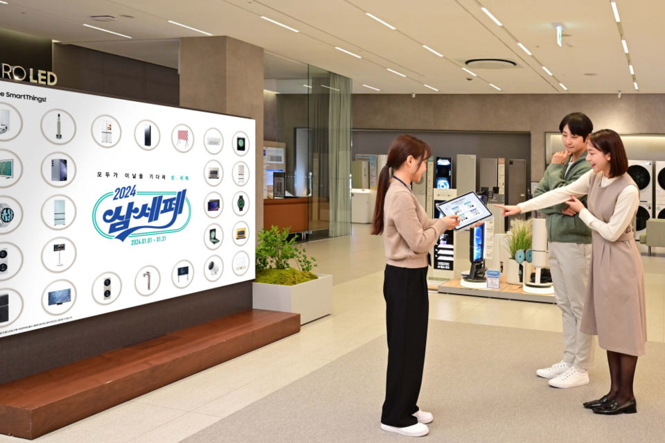 삼성전자 모델이 삼성스토어 대치 본점에서 삼성전자 디테일러(제품 전문 상담사)에게 ‘2024 삼성전자 세일 페스타’의 행사 제품에 관한 설명을 듣는 모습. (사진=삼성전자)