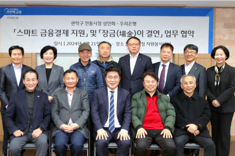 우리은행 관계자들이 관악구 전통시장 상인회와 지난 21일 스마트 금융결제 지원 업무협약을 체결한 뒤 기념사진을 촬영하고 있다. (사진=우리은행)