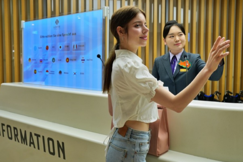 롯데백화점 잠실점에서 외국인 고객이 AI 통역 서비스를 체험하고 있다.(사진=롯데백화점)