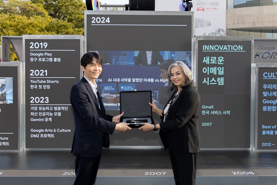 ﻿구글 포 코리아에서 미누 한다(Meenu Handa) 구글 아시아태평양 글로벌 커뮤니케이션 부사장이 기념비적인 대국의 의미를 간직하고자 제작한 동판을 이세돌 9단에게 전달하고 있는 모습. (사진=구글코리아)