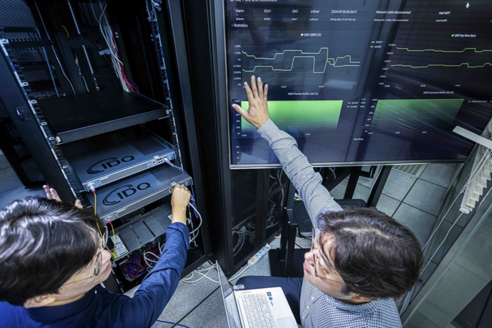 SKT와 QKD 제품 보유기업인 아이디퀸티크 구성원들이 해당 제품을 테스트하는 모습. (사진=SKT)