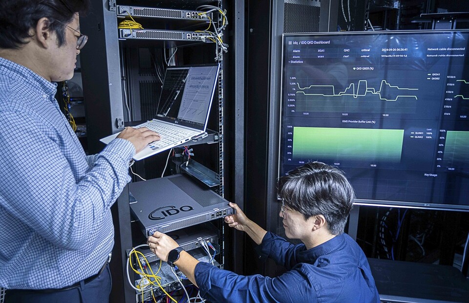 SKT와 QKD 제품 보유기업인 아이디퀸티크 구성원들이 해당 제품을 테스트하는 모습. (사진=SKT)