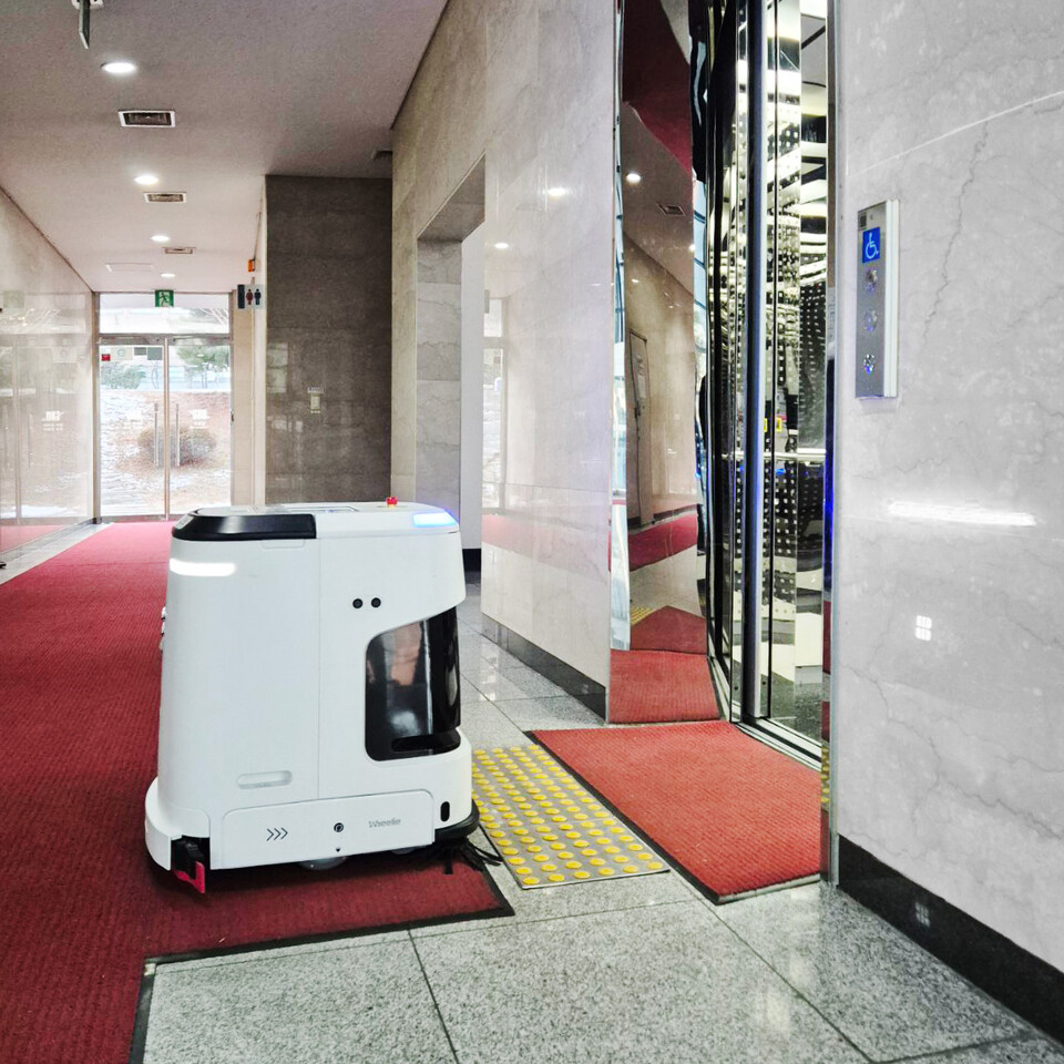 J40 청소로봇 휠리 엘리베이터 탑승 모습. (사진=라이노스)