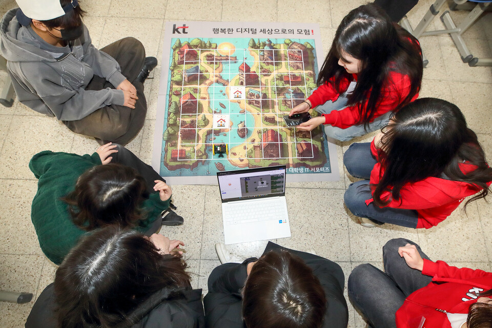 영흥중학교 3학년 학생들이 ‘KT 대학생 IT 서포터즈’ 구성원들에게 AI 코딩 강의를 들으며 실습을 하고 있다. (사진=KT)