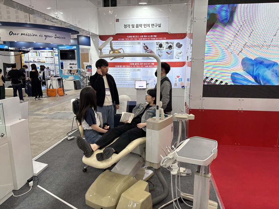 ‘청각 및 음악 인지 연구실(송은성 교수)’에서 만든 ‘치과용 핸드피스의 소음제어 시스템’ 전시 부스를 찾은 관람객이 체험하고 있다. (사진=지스트)