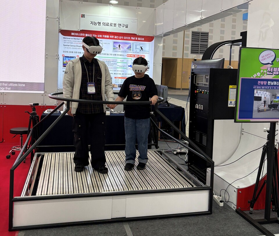 ‘지능형 의료로봇 연구실(윤정원 교수)’에서 만든 ‘초박형 전방향 트레드밀’ 전시 부스를 찾은 관람객이 체험하고 있다. (사진=지스트)