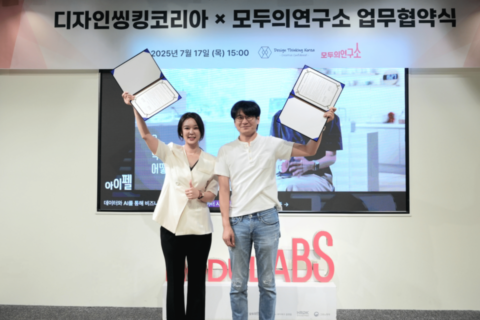 김건희 디자인씽킹코리아 센터장(왼쪽)과 김승일 모두의연구소 대표(오른쪽)가 협약서를 들고 기념 촬영을 하고 있다. (사진=모두의연구소)