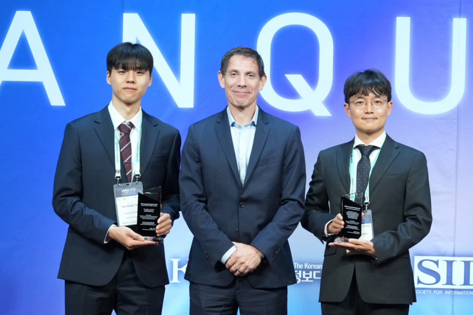 UDC’s Dr. Mike Weaver (center) presenting UDC’s annual Innovative Research and Pioneering Technology Awards to Tae Wook Yang (left) and Dong Jun Kim (right).