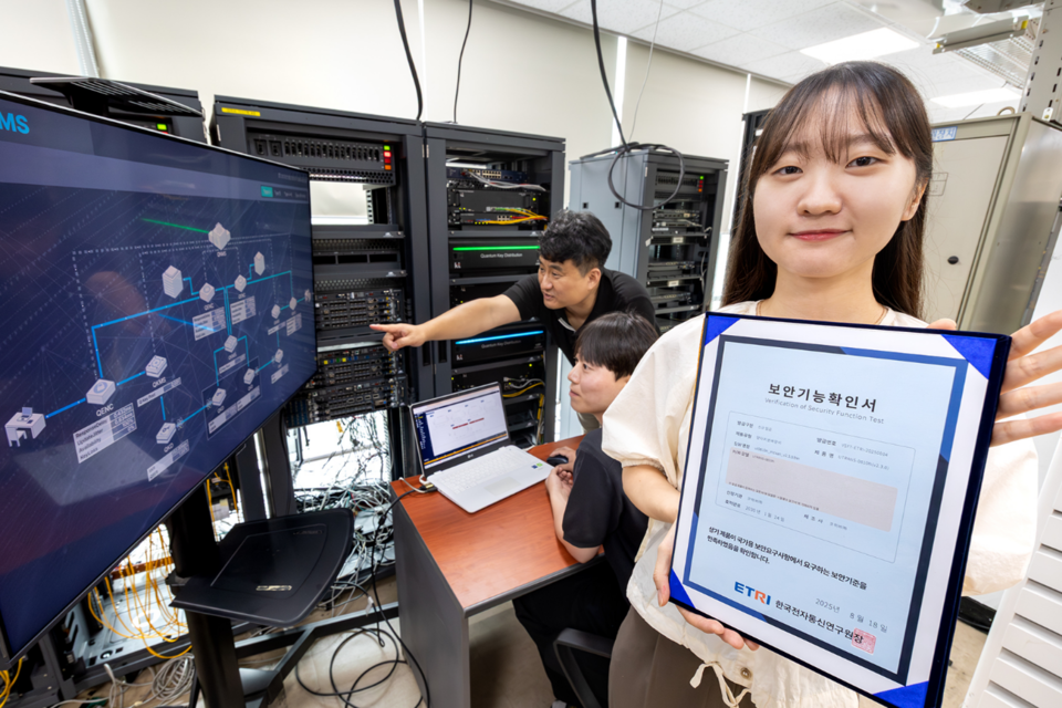 KT와 코위버 직원이 양자키분배 기술 적용 장비를 점검하며 보안 인증서를 소개하는 모습. (사진=KT)